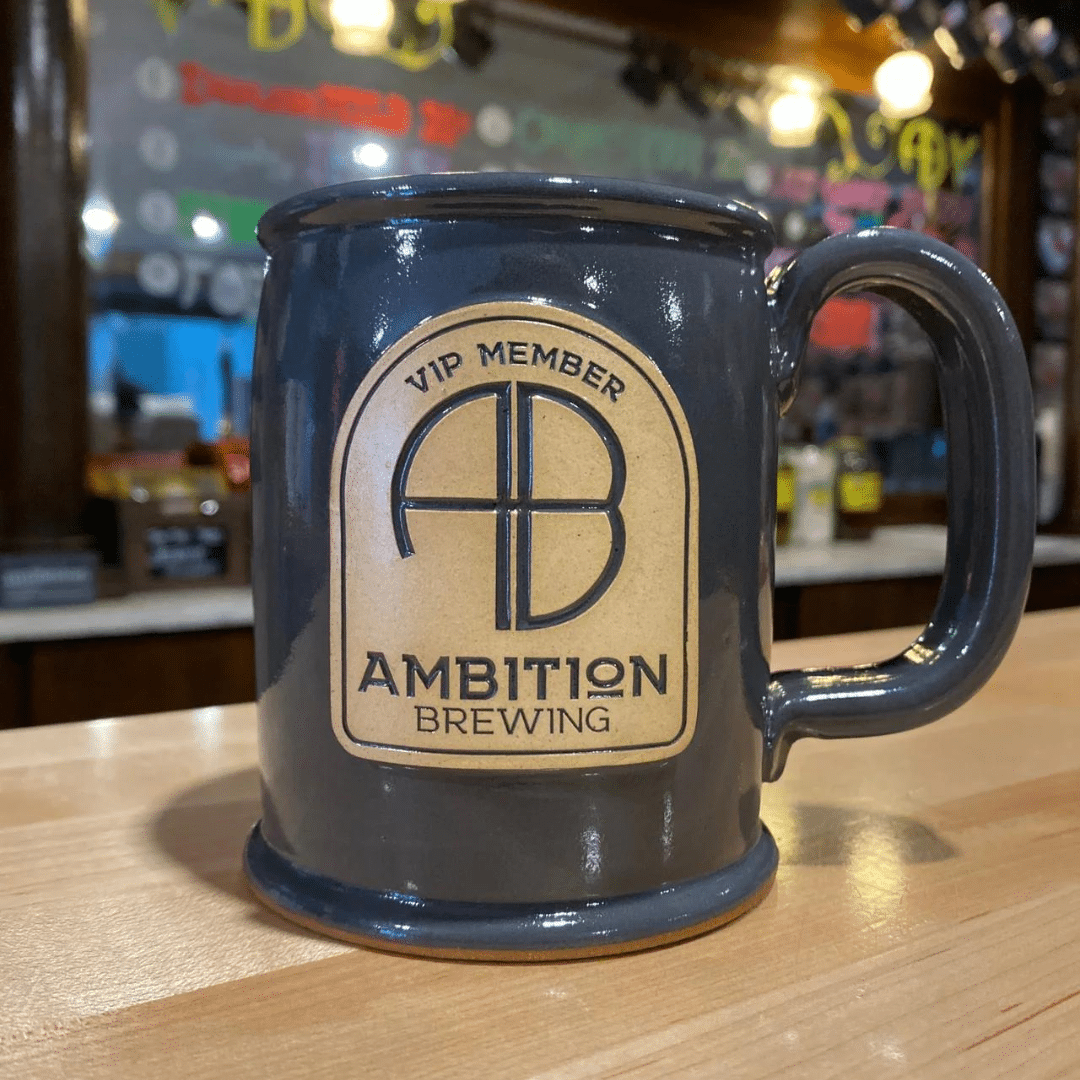 Ceramic mug on a bar top with AB logo and Ambition Brewing